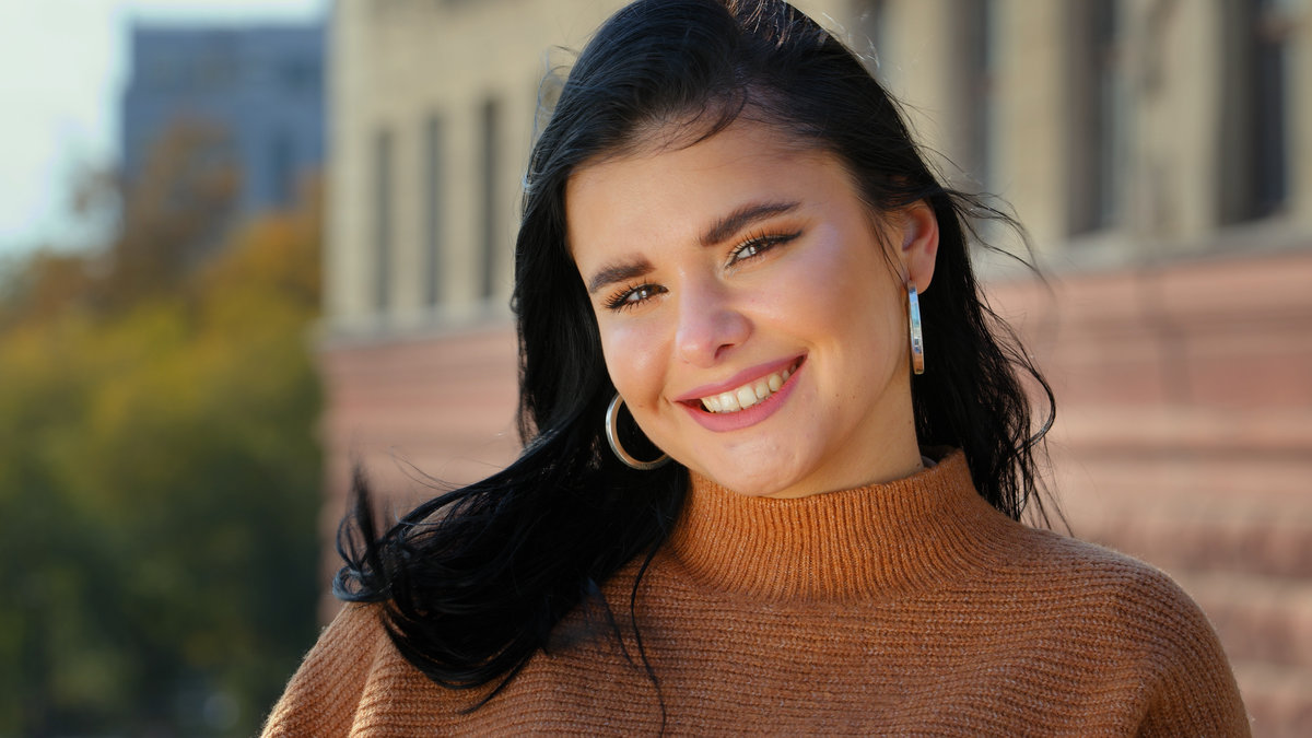 Young attractive hispanic girl student model looking at camera posing standing alone outdoors for close-up portrait professional beautiful smiling with white teeth dental smile happy carefree woman. High quality 4k footage